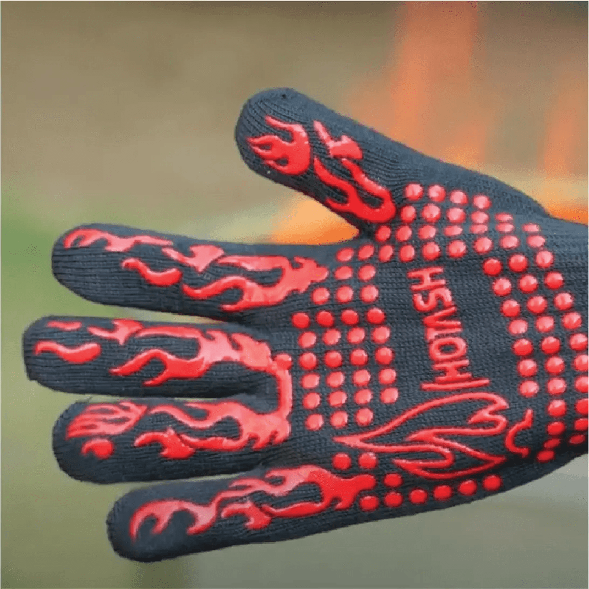 A durable black BBQ glove with vibrant red non-slip dots and flame accents, designed for handling high heat.
